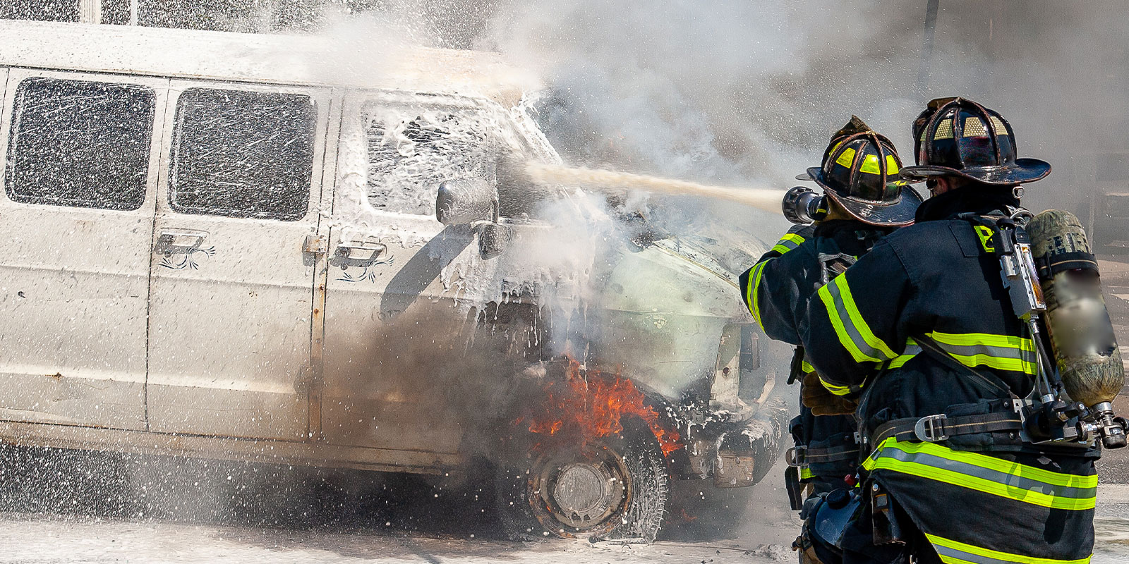 Firematic training: firefighters spraying water on a van fire